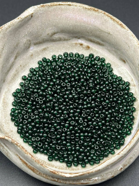 small container filled with emerald green beads